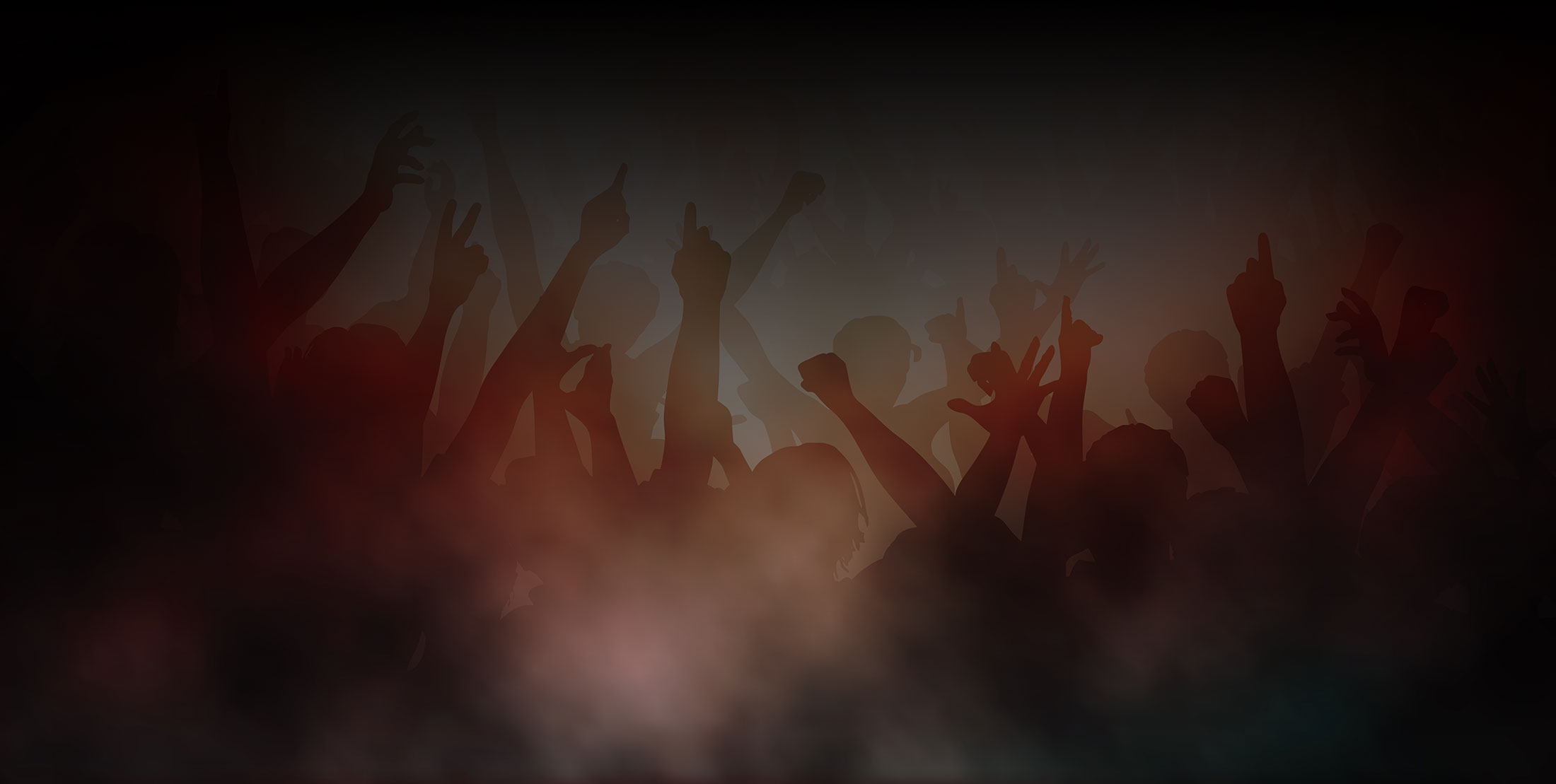 Silhouetted festival crowd with raised arms and hands inside drifting haze, lit in deep red and amber against a dark stage backdrop